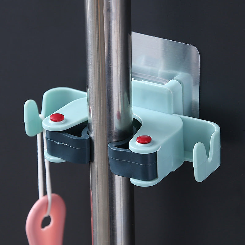 Light blue adhesive mop and broom wall clip gripping a silver handle with side hooks