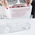 White removable drain basket lifted from a clear vented produce crisper